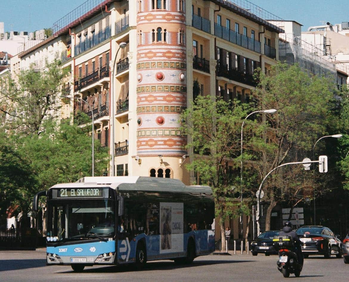 A city bus driving through the center of Madrid, showcasing the city’s efficient public transport network.