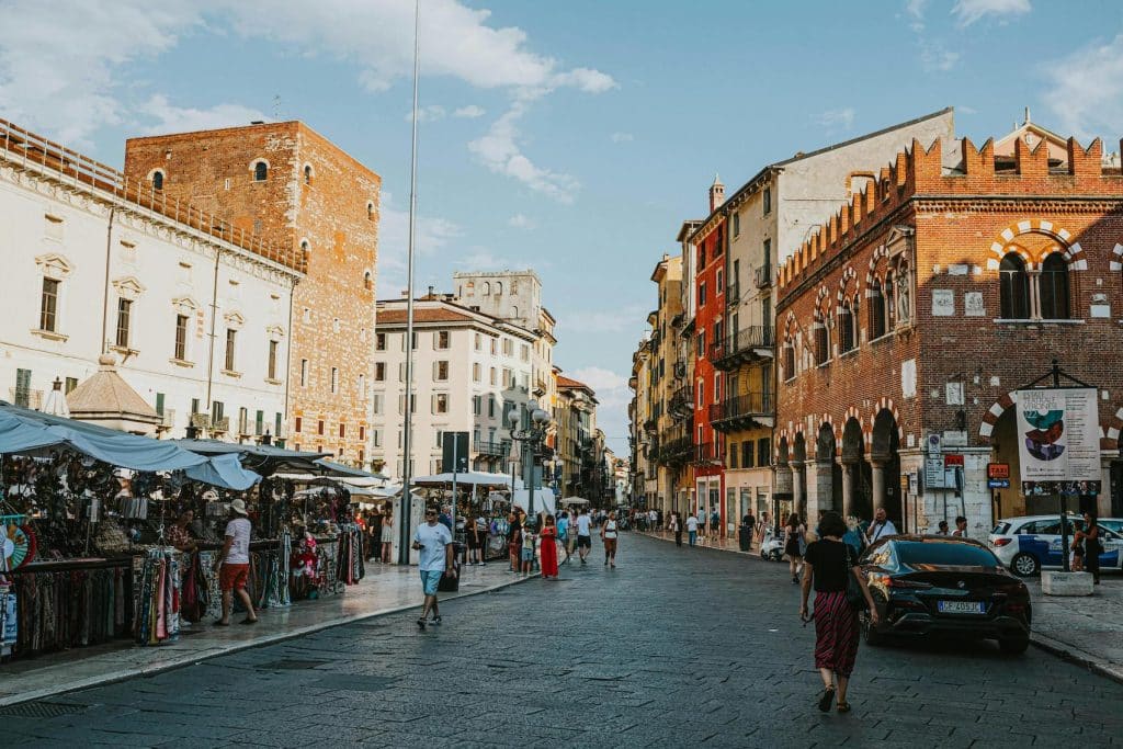 Shoppers browsing fresh produce at a local market in Rome, highlighting everyday living expenses in the city.