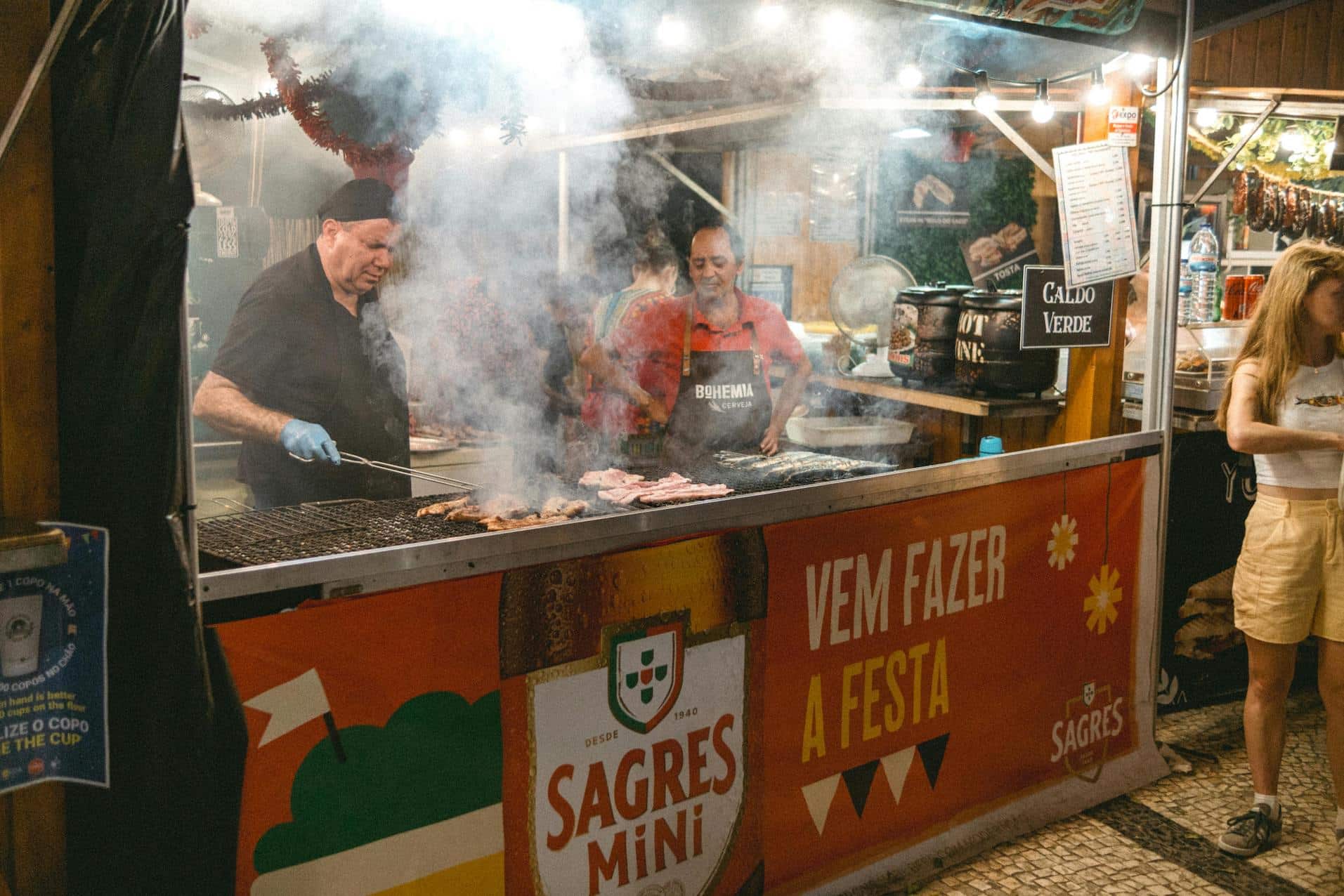 Street vendor grilling fresh sardines during a local festival, highlighting Portugal’s vibrant street food culture.
