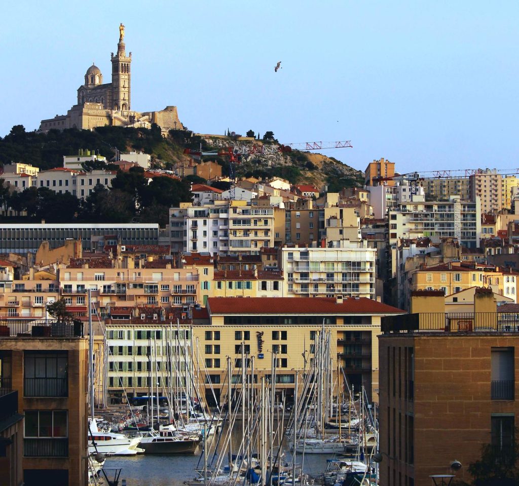 A panoramic view of Marseille’s Old Port with boats and vibrant cafés, highlighting must-visit attractions and local culture.