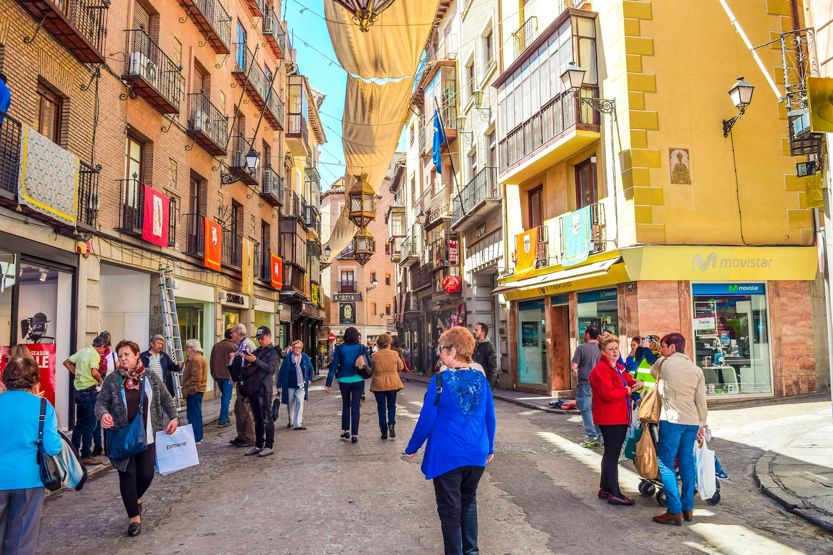 A lively street scene in Spain with people interacting, representing everyday Spanish social etiquette and manners.