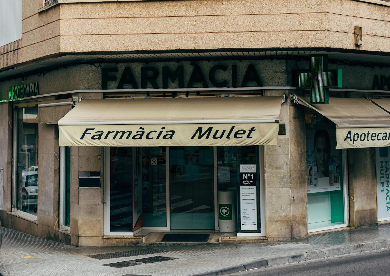 A pharmacy in Spain with the recognizable green cross, an essential part of the country's healthcare system for expats and visitors.