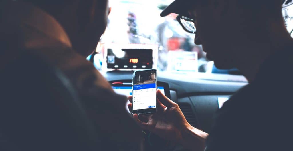 Rideshare driver using a smartphone app to navigate to a passenger pickup location in Portugal.