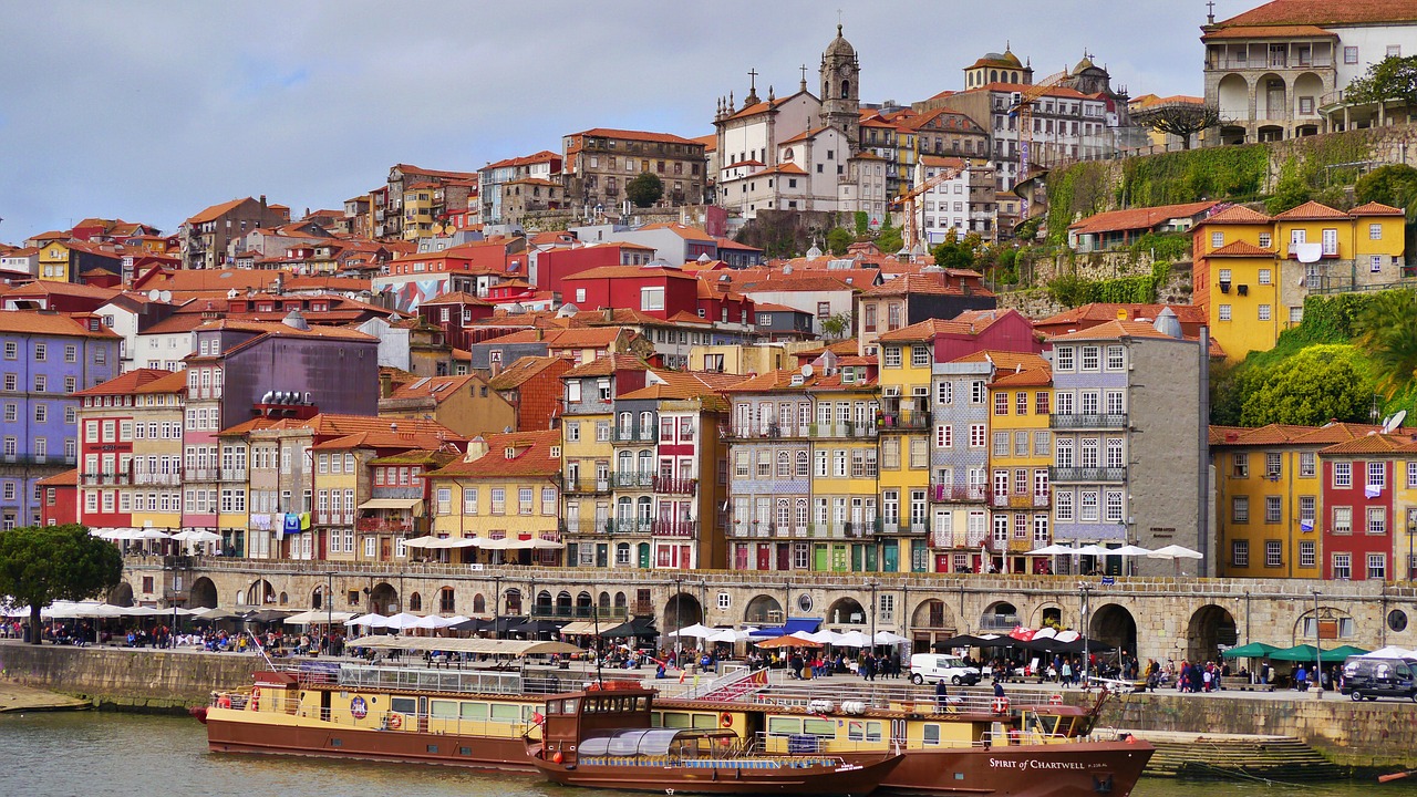 Outdoor restaurants along Porto’s Douro River with people dining and enjoying scenic views, showcasing the city’s vibrant culinary scene and riverside atmosphere.
