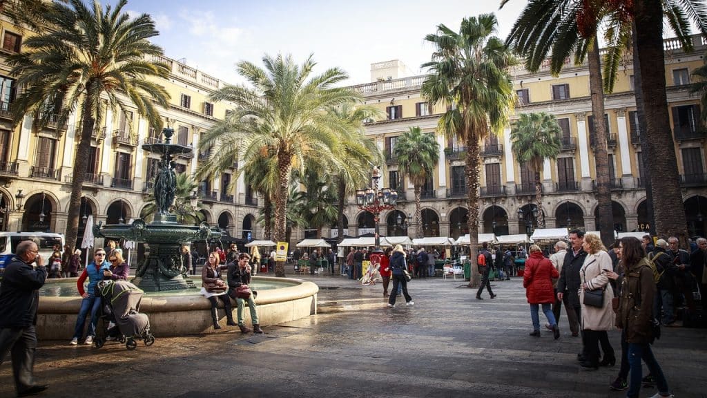 A vibrant street scene in Barcelona, with locals enjoying outdoor cafes, iconic architecture, and cultural traditions, reflecting the city's dynamic daily life.