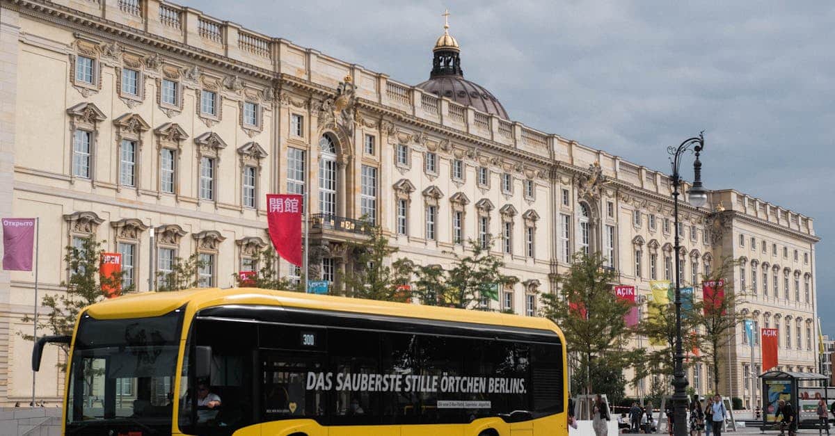 A yellow Berlin BVG bus passing the historic Humboldt Forum, representing public transportation options for expats in Germany’s capital.