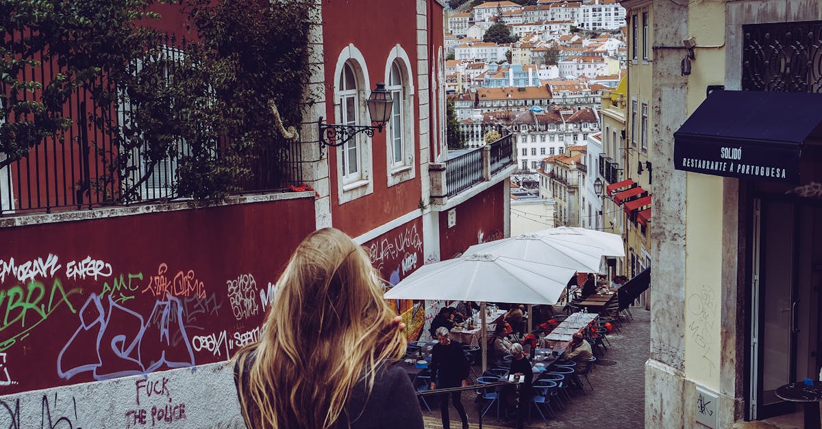 Woman walking down a graffiti-lined street in Lisbon's Alfama district, illustrating everyday safety considerations for expats exploring local neighborhoods.