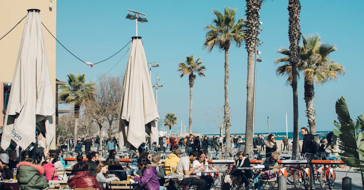 Colorful outdoor café in Barcelona by the beach, with people enjoying a sunny day and traditional dining experiences.