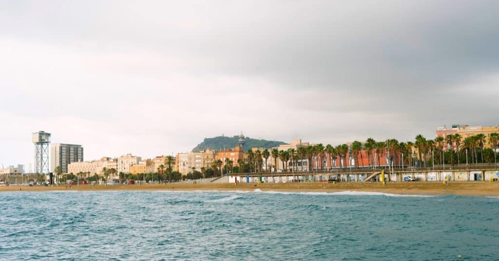 Barceloneta Beach in Barcelona with locals enjoying the sand and sea during sunset.