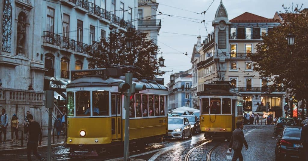 Scenic view of trams navigating the charming streets of Lisbon at dusk, capturing the city's urban life, transportation, and historic atmosphere.