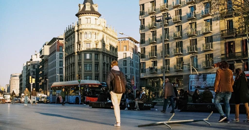 A vibrant Barcelona street scene with classic architecture, active pedestrians, and traffic, showcasing the city’s dynamic urban transport life.