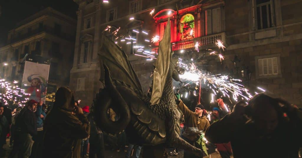 Exciting night scene of a cultural festival in Barcelona with fireworks and performers, showcasing the city’s vibrant festival culture.