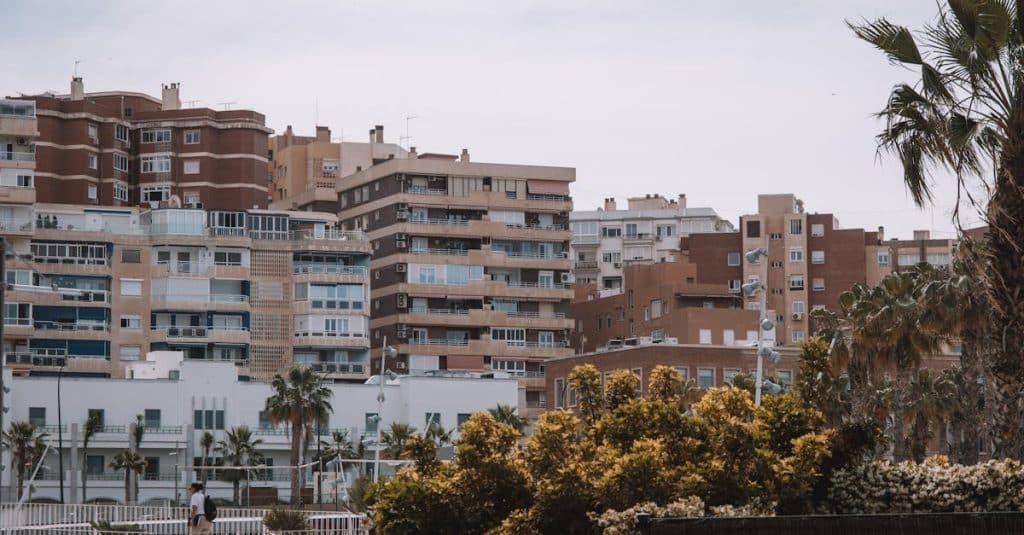 Contemporary residential buildings in Málaga, Spain, with palm trees, representing the rental market for tenants in Spain.