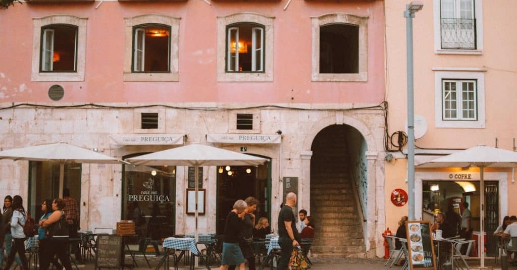 A lively Lisbon street with people passing by cafés and colorful buildings, capturing the city’s vibrant atmosphere and everyday local life.