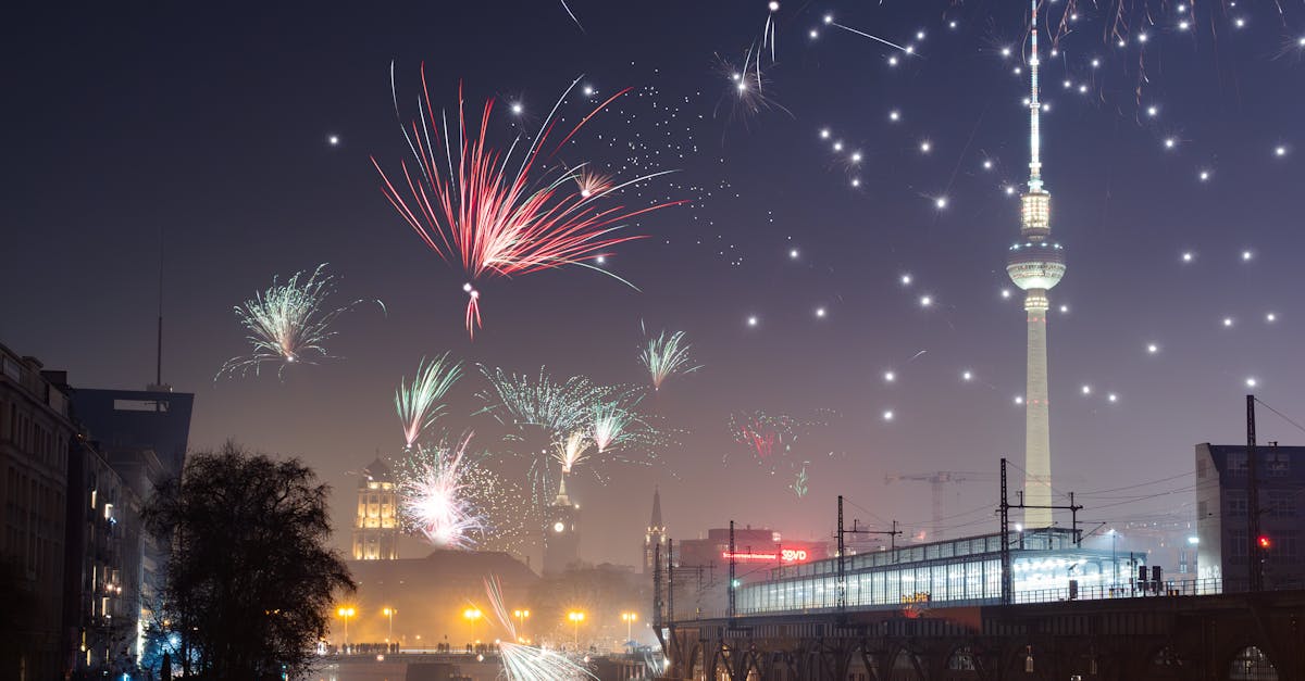 Captivating fireworks light up the Berlin night sky above the iconic TV Tower, reflecting beautifully in the river, celebrating New Year's Eve in Germany’s capital.