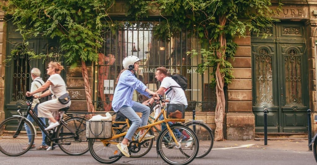 Cyclists using bike lanes in a French city, highlighting eco-friendly transport options like bike-sharing and sustainable mobility in France.