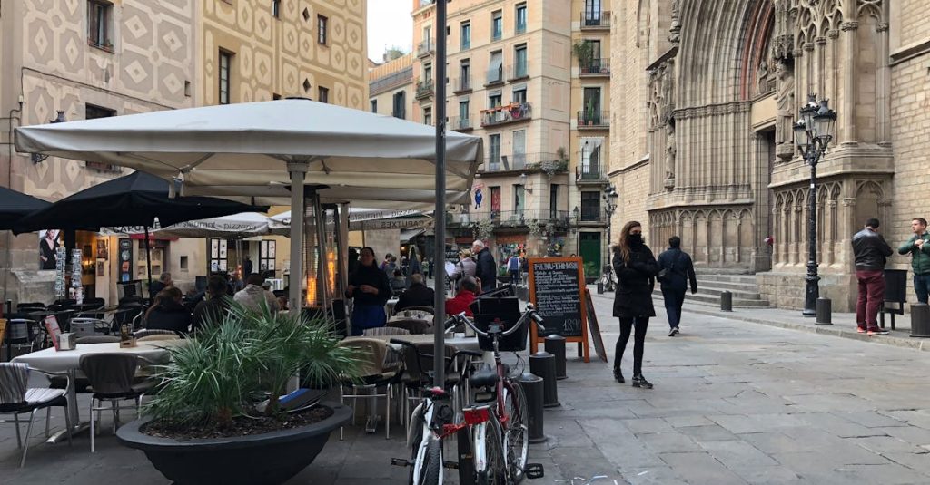 People enjoying a lively street scene by Santa María del Mar in Barcelona, representing social opportunities for expats in Spain.
