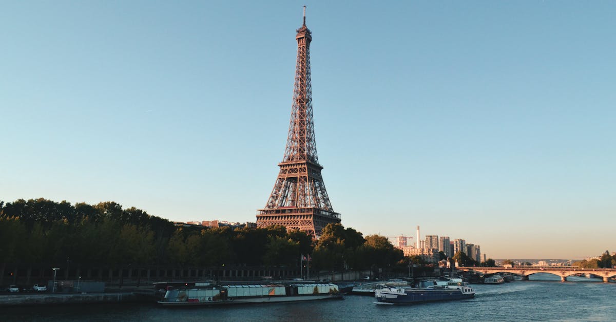 Scenic view of the Eiffel Tower and Seine River at sunset, showcasing iconic Parisian architecture and the city's residential areas.
