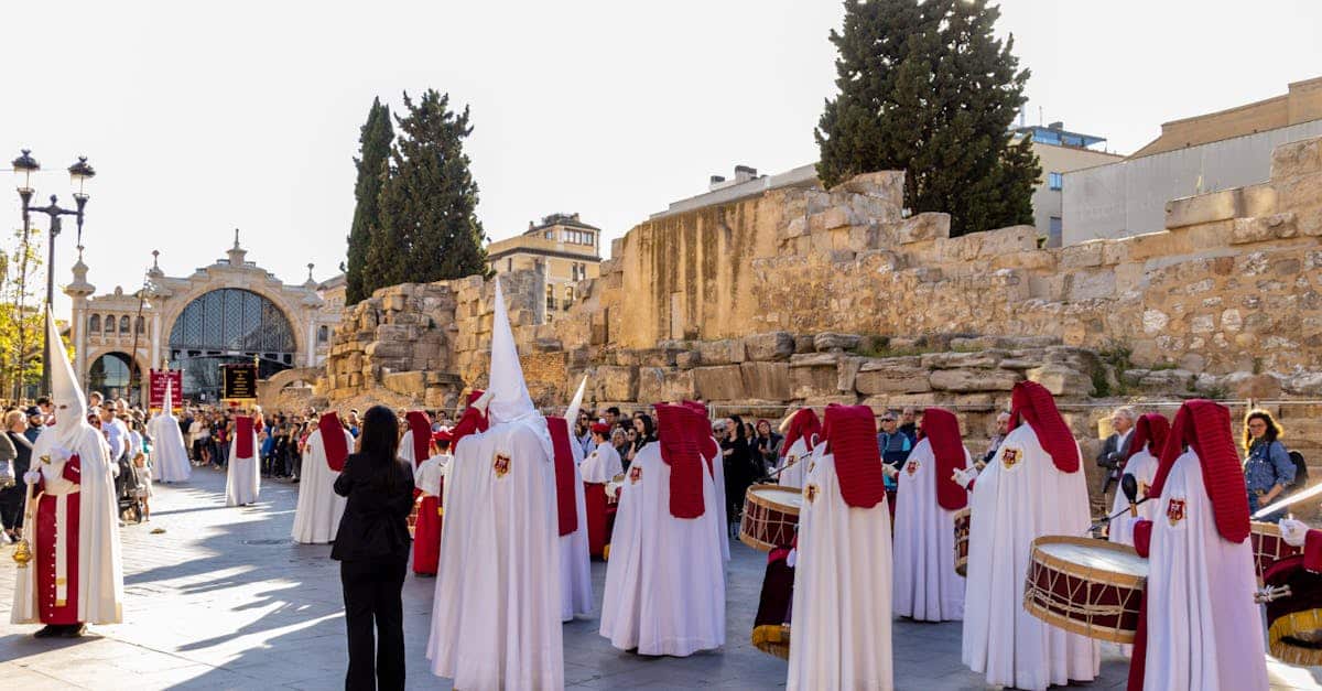 Majestic Holy Week procession in Zaragoza with people wearing white capirotes, showcasing the deep cultural and religious traditions of Spain.