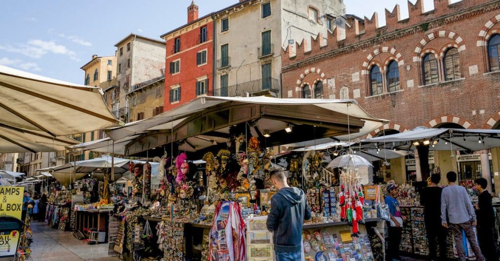 Group of people enjoying a vibrant street market, reflecting the community-driven festivals and local celebrations found in Milan and Rome.