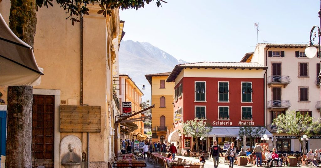 People enjoying sunny outdoor cafés and shops on a picturesque Italian street, reflecting work-life harmony in Milan and Rome.