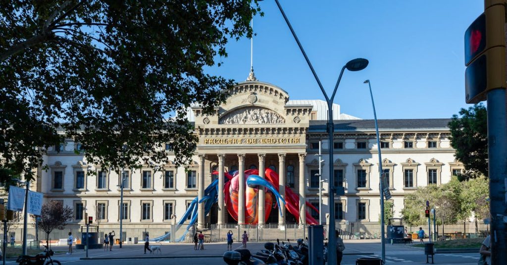 Facade of the University of Barcelona with vibrant art installation on a sunny day, representing the dynamic educational environment.