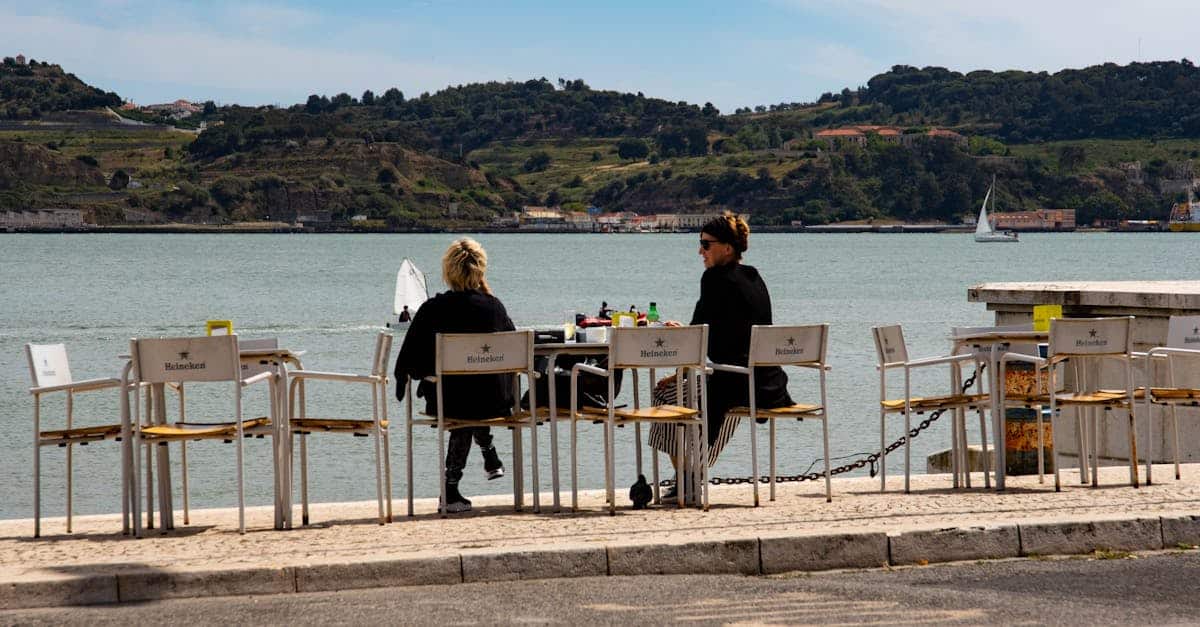 Relaxed outdoor dining overlooking the waterfront and hills in Lisbon, Portugal, offering a scenic and authentic culinary experience.