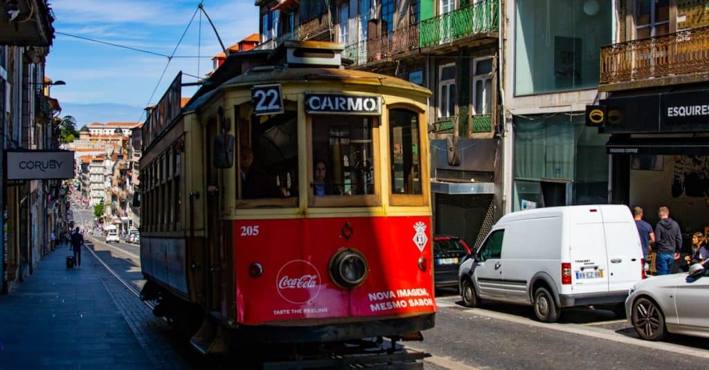 Colorful historic tram on bustling Carmo Street in Porto, showcasing the city’s urban life and affordable public transportation options for expats.