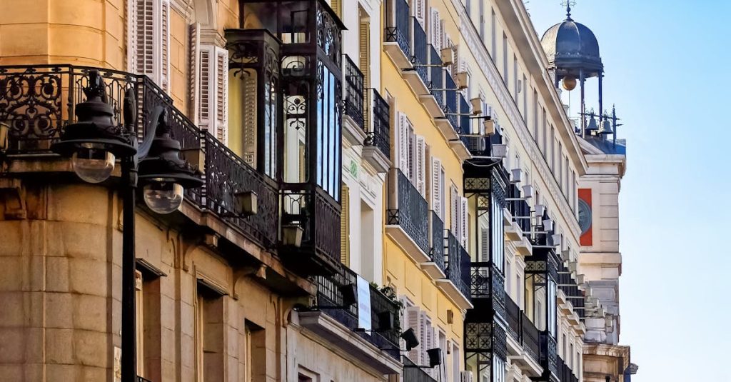Elegant historic buildings with ornate balconies in Madrid, Spain, showcasing the city's vibrant rental market and housing options.
