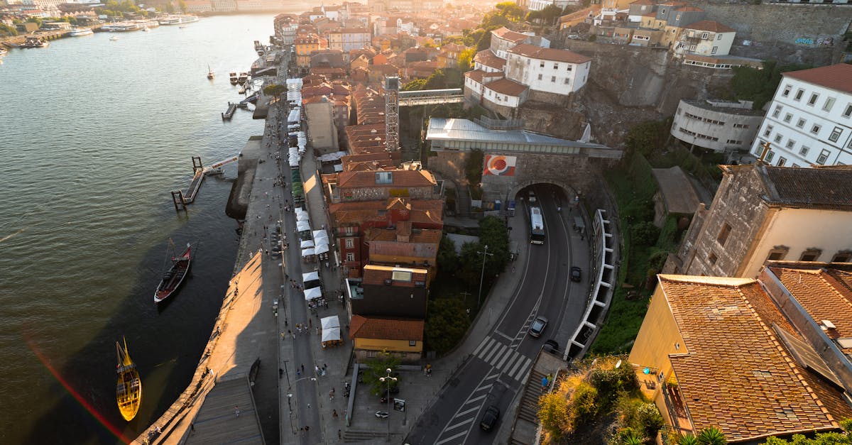 Scenic aerial view of Porto, Portugal, featuring the Douro River, traditional buildings, and roads at sunset, capturing the city's vibrant neighborhoods and rich cultural landscape.