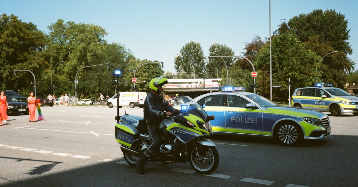 German police officers with patrol cars and a motorcycle managing daytime traffic control in Berlin, ensuring public safety.