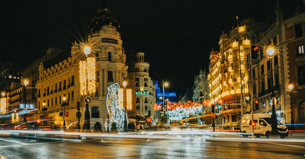 Festive holiday lights illuminating the Metropolis Building on Gran Vía in Madrid, Spain, celebrating seasonal winter activities.