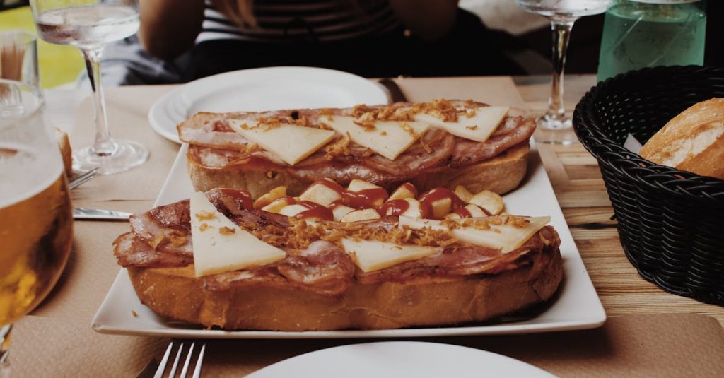 A delicious Spanish toast topped with ham, cheese, and garnish, served at an outdoor restaurant in Cuenca, Spain, showcasing traditional Spanish cuisine.
