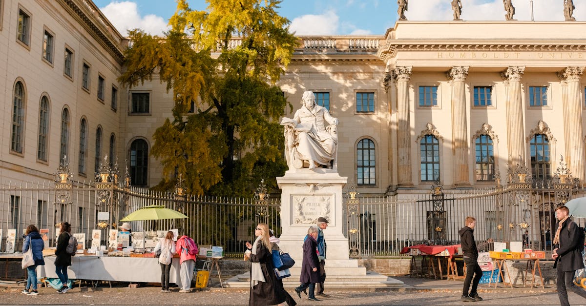 A bustling street scene at Humboldt University in Berlin, featuring market stalls and pedestrians, showcasing student life and academic culture in Germany.