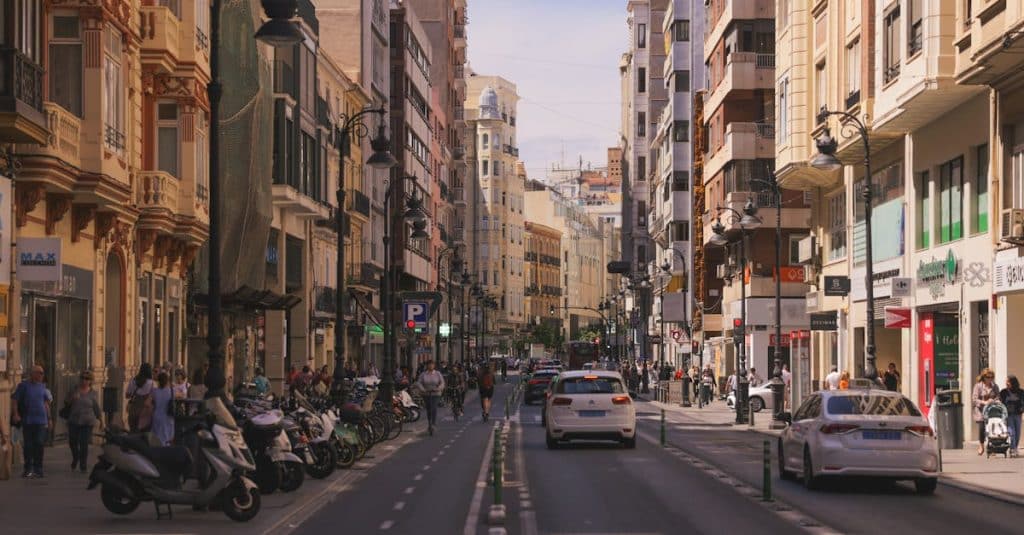 A lively street in Valencia, Spain, featuring classic architecture, outdoor cafés, and vibrant city life.