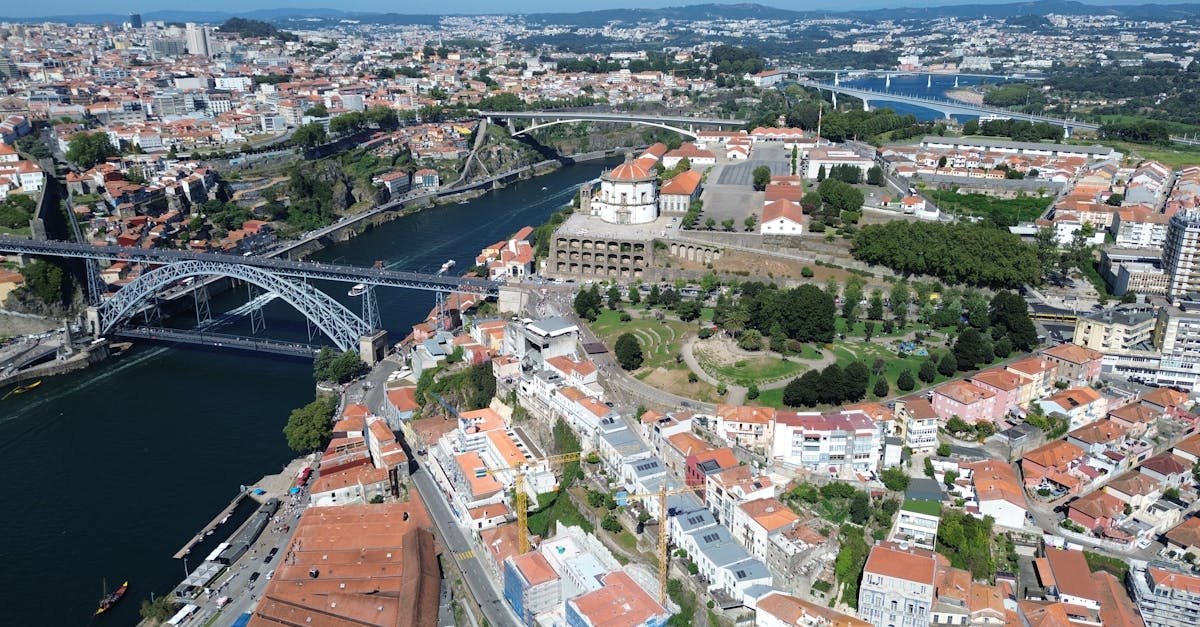 Stunning aerial view of Porto, Portugal, featuring the famous Dom Luís I Bridge and the Douro River, showcasing the city’s iconic landmarks and vibrant neighborhoods.