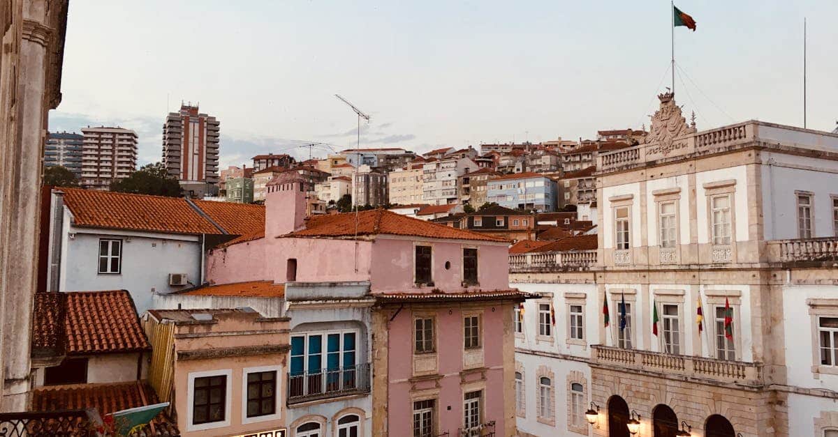 A beautiful view of Coimbra's historic architecture with pastel buildings under a clear evening sky, showcasing the city’s charm and cultural heritage.