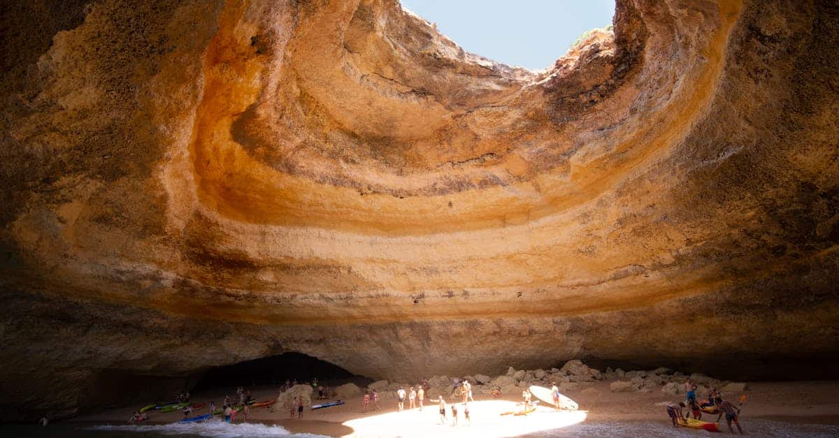 Stunning view of the Benagil sea cave in Portugal with sunlight illuminating the sandy beach, showcasing one of the country’s most iconic natural wonders.
