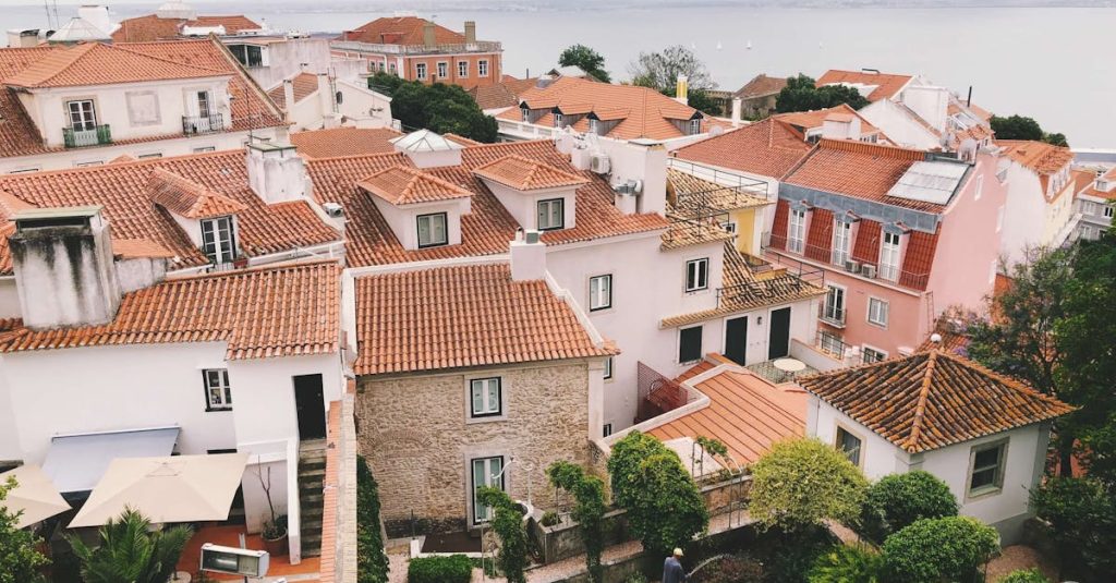 Picturesque view of Lisbon's terracotta rooftops and coastline from above, showcasing the city's charming architecture and scenic landscape.