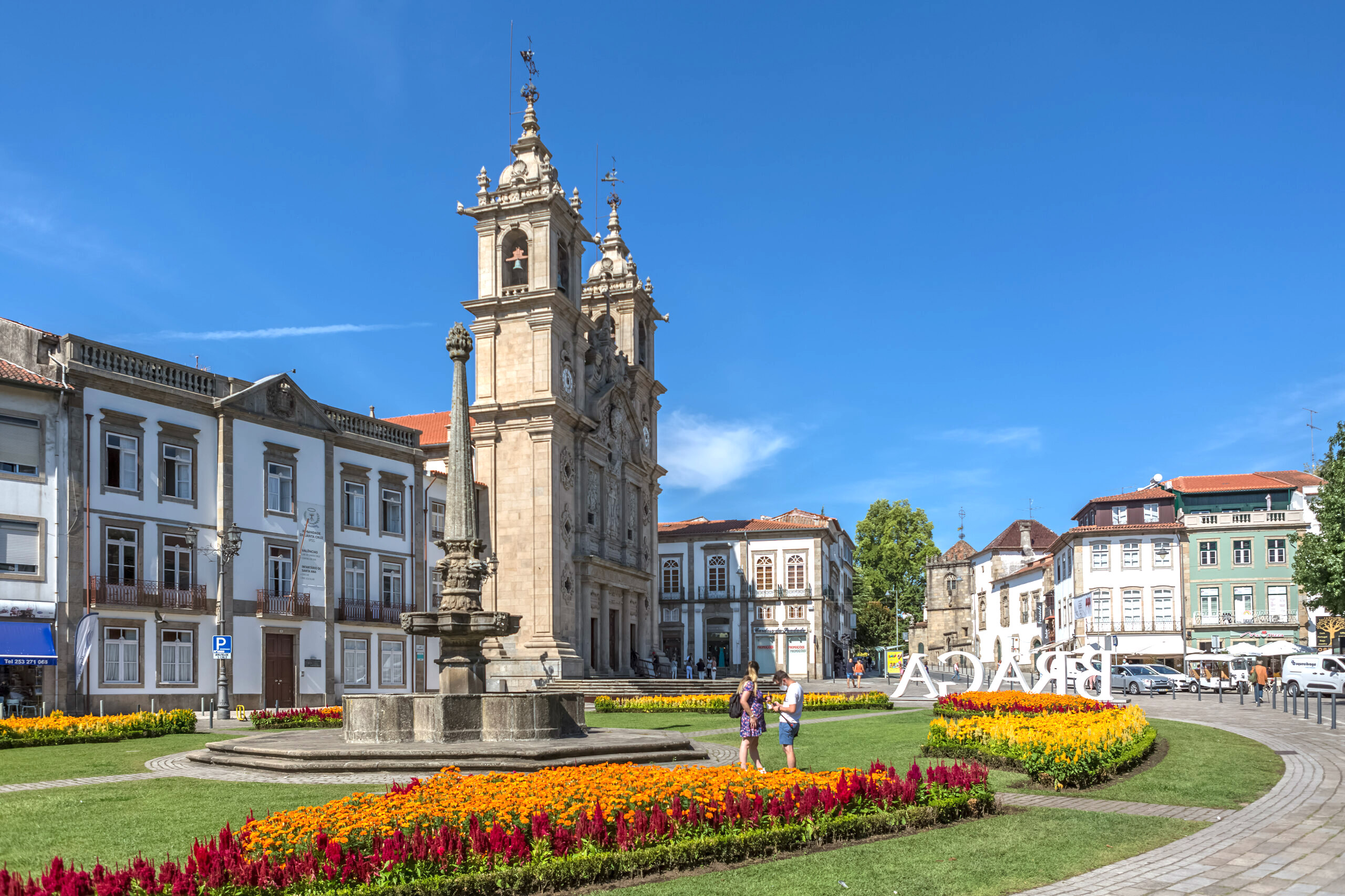 Scenic view of Braga’s iconic garden in the city center, with a couple strolling, Saint Marcos Church, and Hotel Vila Galé in the background.