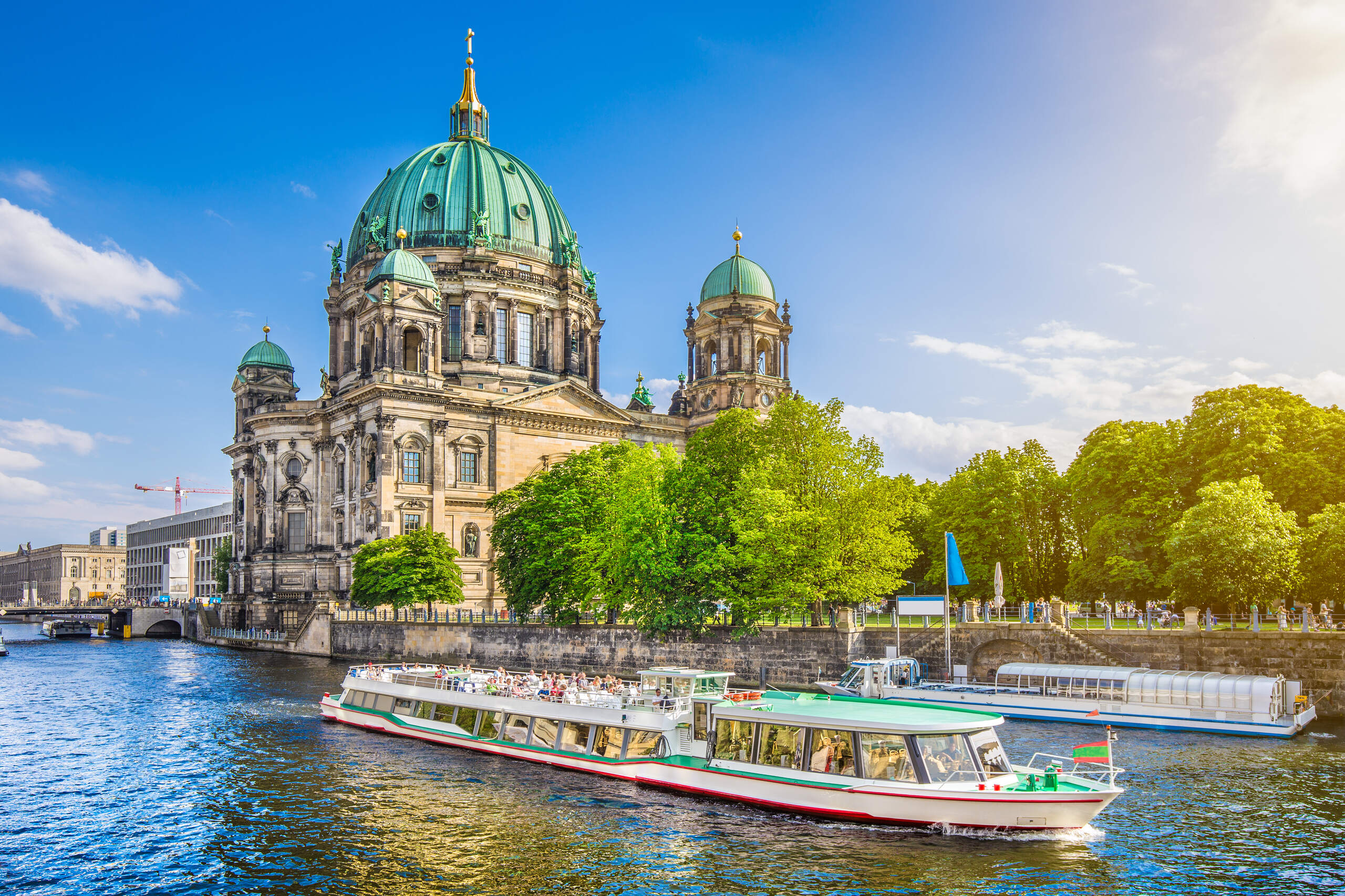 Panoramic city view of Berlin, Germany, featuring the Fernsehturm (TV Tower), Spree River, and city skyline.