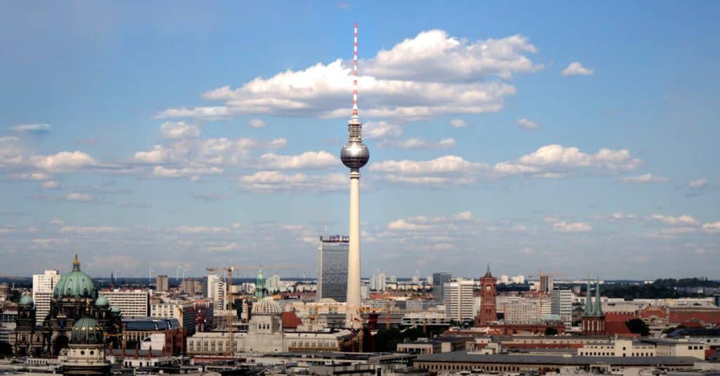 Panoramic view of Berlin’s skyline with the Fernsehturm TV Tower under a clear blue sky, representing the city's neighborhoods and cost of living.
