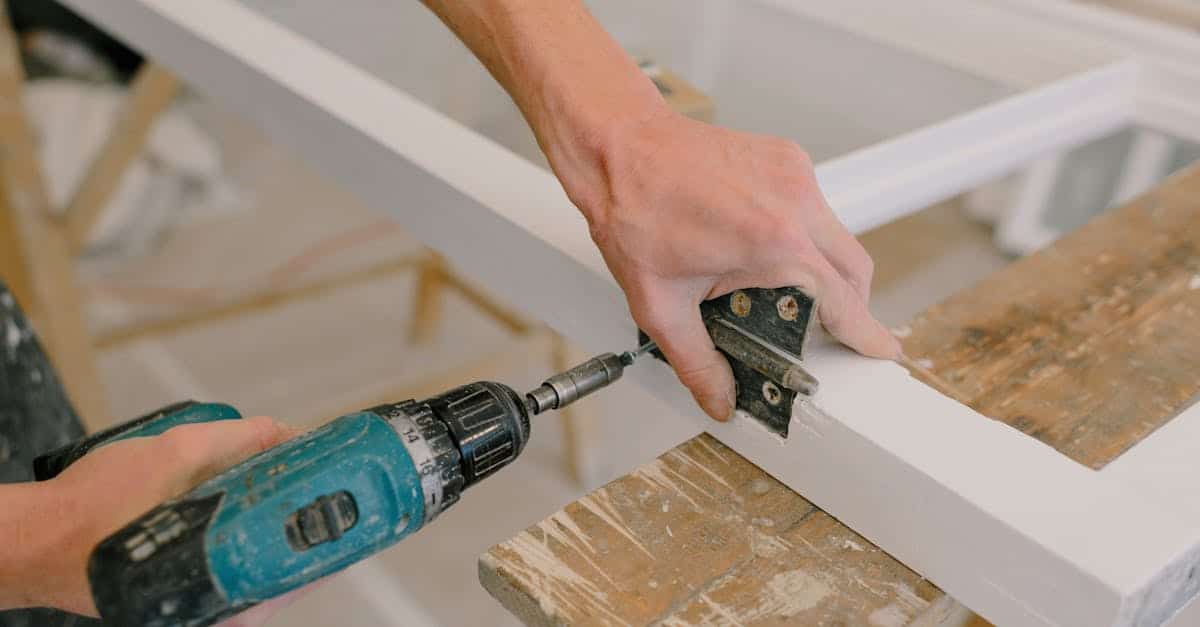An unrecognizable professional using a cordless screwdriver to install a metal hinge on a wooden window, showcasing DIY furniture transformation and repair techniques on a budget.