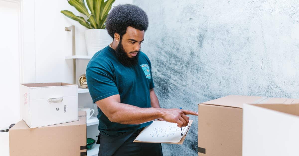 A mover checking an inventory list while organizing cardboard boxes in a new apartment, symbolizing a well-organized moving abroad process.