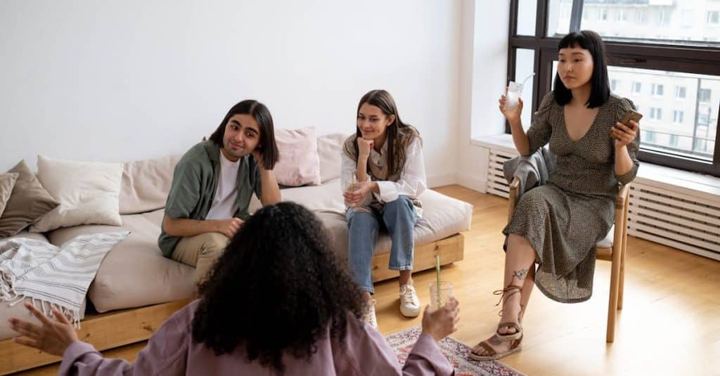 Friends enjoying a laid-back gathering in a stylish living room, fostering open communication and maintaining a peaceful co-living environment.