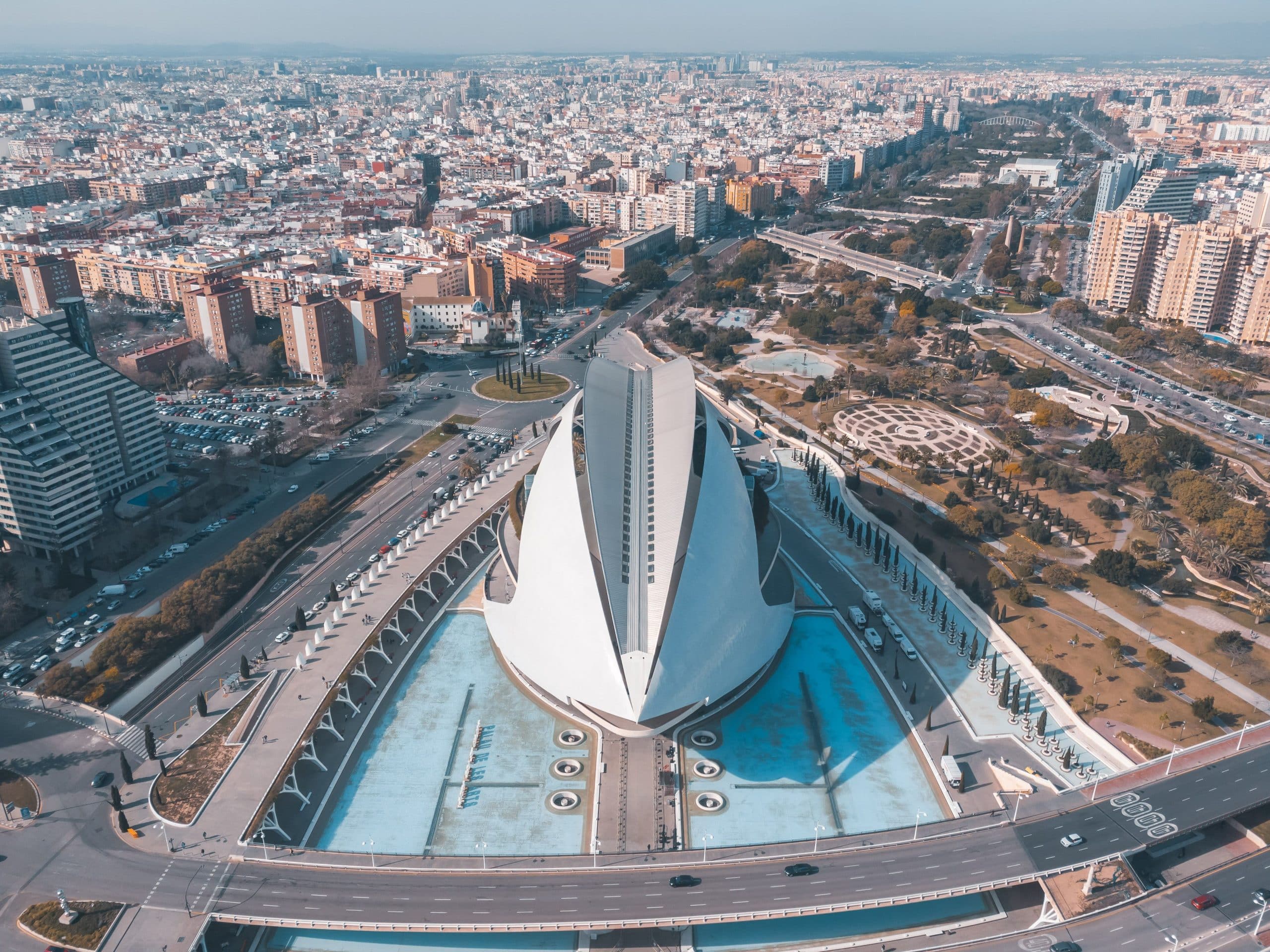 Stunning aerial shot of modern architectural landmark surrounded by urban cityscape.