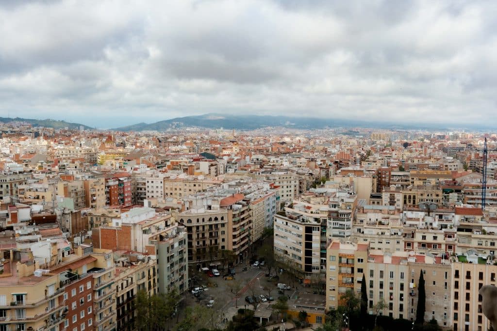 Stunning aerial view of Barcelona's expansive cityscape with cloudy skies.